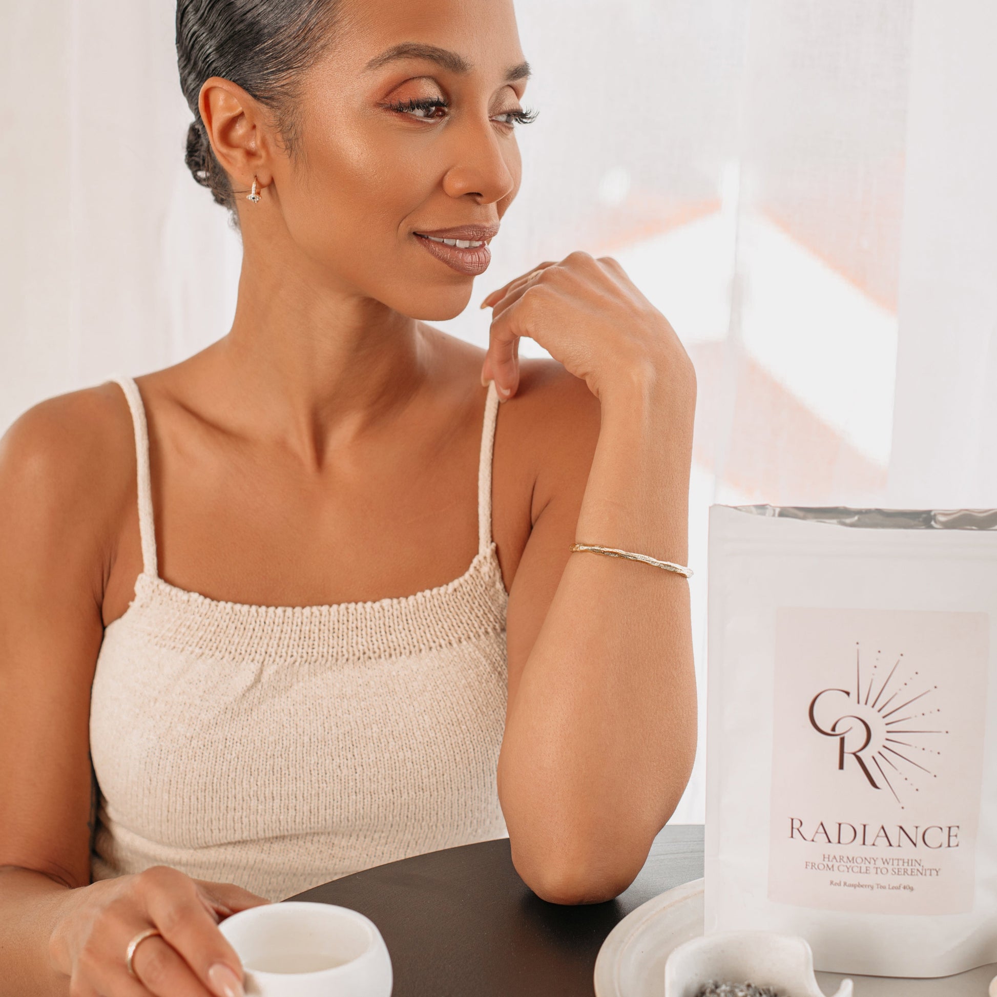 Woman enjoying Radiance Loose Leaf Tea during beauty self-care routine
